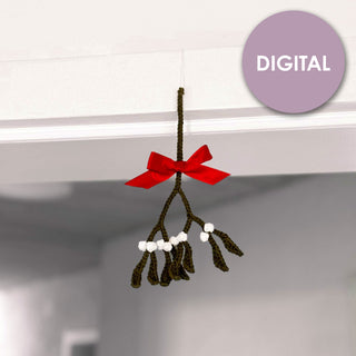 gehäkelter mistelzweig mit roter schleife an türrahmen befestigt